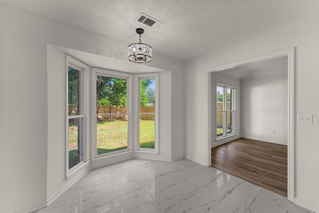 5437 Chatham Woods Ct, Columbus, GA 31907 - unfurnished dining area with marble finish flooring, a chandelier, and a textured ceiling