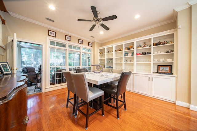 dining room with ceiling fan, ornamental molding, and light hardwood / wood-style floors