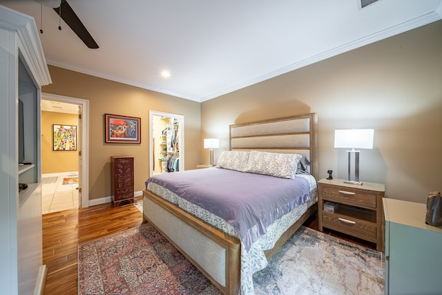 bedroom featuring ornamental molding, a spacious closet, ceiling fan, and a closet