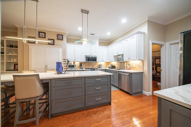 kitchen featuring sink, appliances with stainless steel finishes, white cabinetry, gray cabinetry, and decorative light fixtures