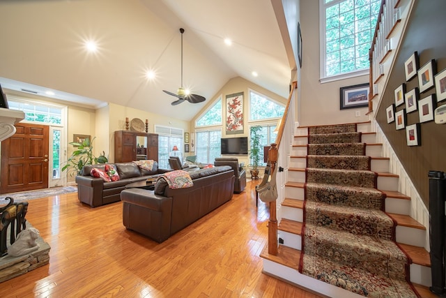 living room featuring high vaulted ceiling, light hardwood / wood-style floors, and ceiling fan