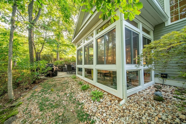 view of home's exterior featuring a sunroom and a patio area