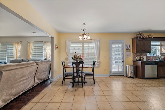 dining room featuring an inviting chandelier, light tile patterned floors, a wealth of natural light, and sink