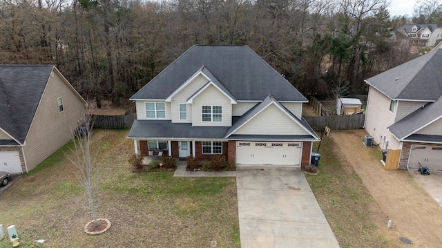 view of front of property featuring central AC, a garage, covered porch, and a front yard