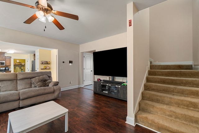 living room featuring dark wood-type flooring and ceiling fan