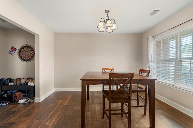 dining area with an inviting chandelier, plenty of natural light, and dark hardwood / wood-style floors