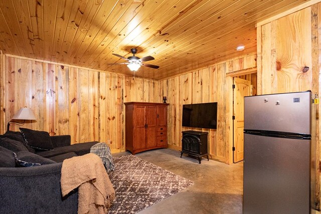 153 N Whatley Rd, Lagrange, GA 30240 - living area featuring concrete floors, wood walls, a ceiling fan, wood ceiling, and a wood stove
