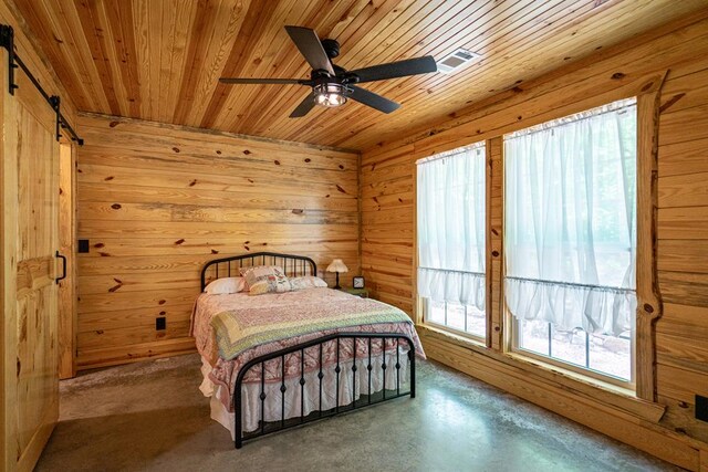 153 N Whatley Rd, Lagrange, GA 30240 - bedroom featuring wooden ceiling, a barn door, wooden walls, finished concrete floors, and a ceiling fan
