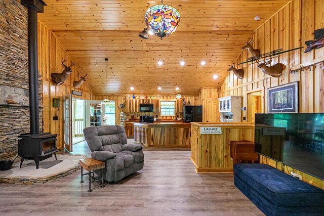 153 N Whatley Rd, Lagrange, GA 30240 - living room featuring a wood stove, wooden ceiling, light wood-type flooring, high vaulted ceiling, and wooden walls