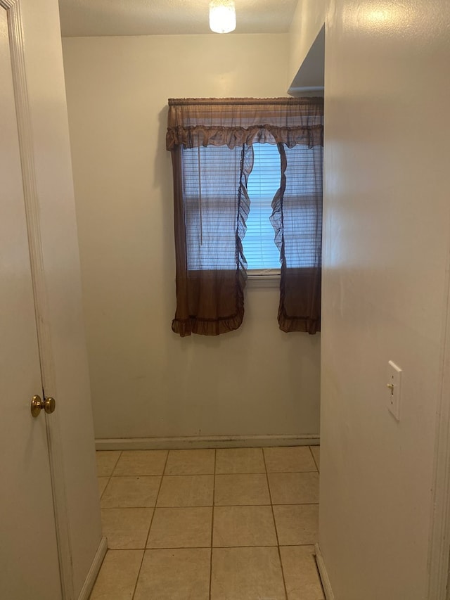 interior space with light tile patterned flooring and baseboards