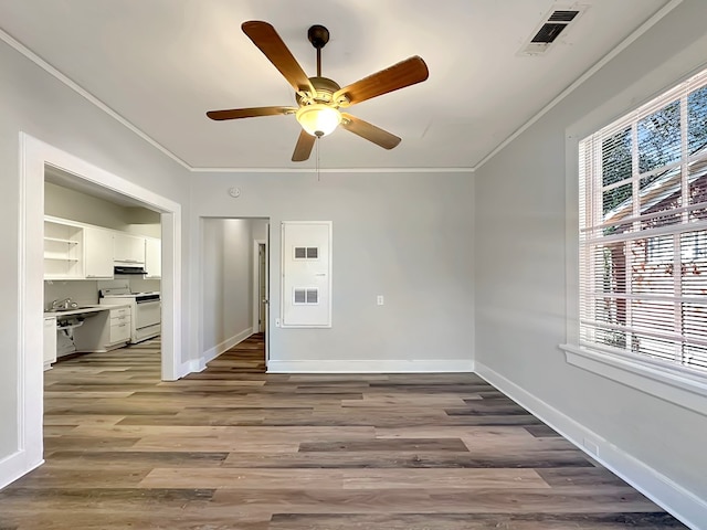 empty room featuring wood-type flooring, ceiling fan, and crown molding