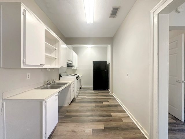 kitchen featuring white cabinets, black refrigerator, white electric range, and sink