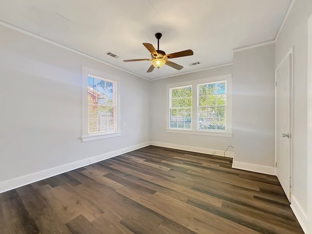 empty room featuring dark hardwood / wood-style flooring, crown molding, and a wealth of natural light