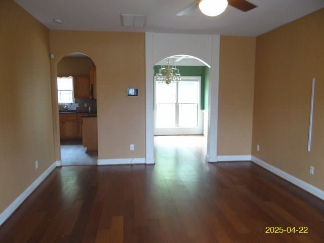 1111 Richland Dr, Columbus, GA 31907 - spare room with ceiling fan with notable chandelier, arched walkways, and dark wood finished floors