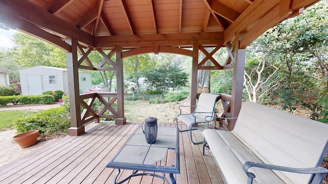 wooden deck with a storage shed and an outdoor structure