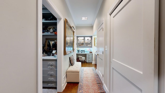 corridor with ornamental molding and dark wood-style flooring