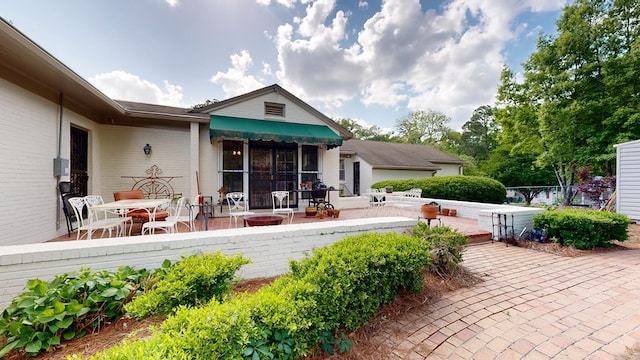 rear view of property with fence, outdoor dining space, and a patio area