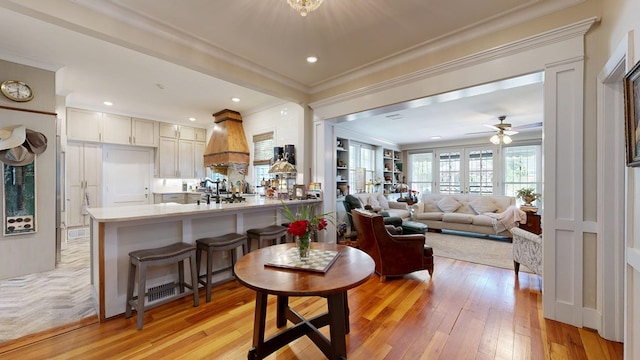 living room with crown molding, recessed lighting, ceiling fan, and light wood-type flooring