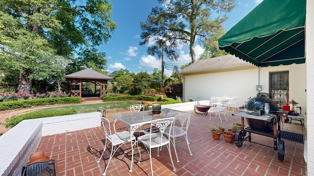 view of patio with area for grilling, a gazebo, and outdoor dining area