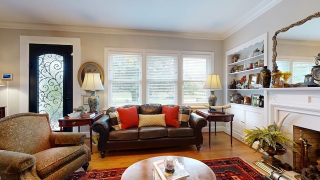 living area featuring plenty of natural light, ornamental molding, wood finished floors, and built in shelves