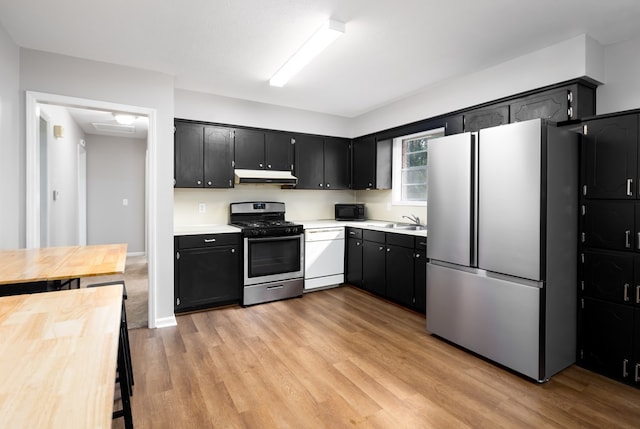 kitchen featuring stainless steel appliances, sink, and light wood-type flooring