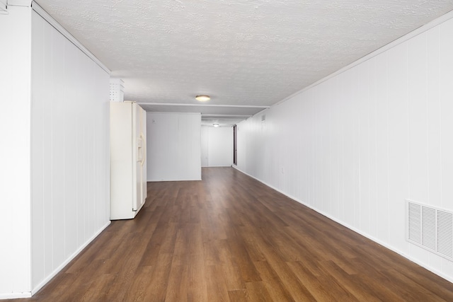 spare room featuring dark hardwood / wood-style floors and a textured ceiling