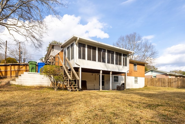 rear view of house with a sunroom, cooling unit, and a lawn