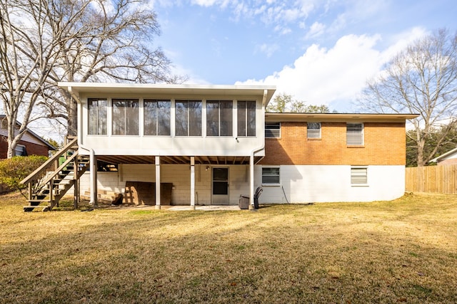 rear view of property with a yard and a sunroom