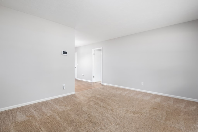 unfurnished room featuring light carpet