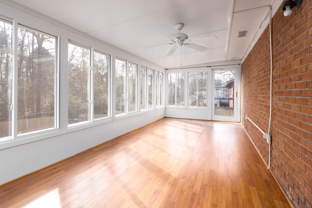 unfurnished sunroom with ceiling fan