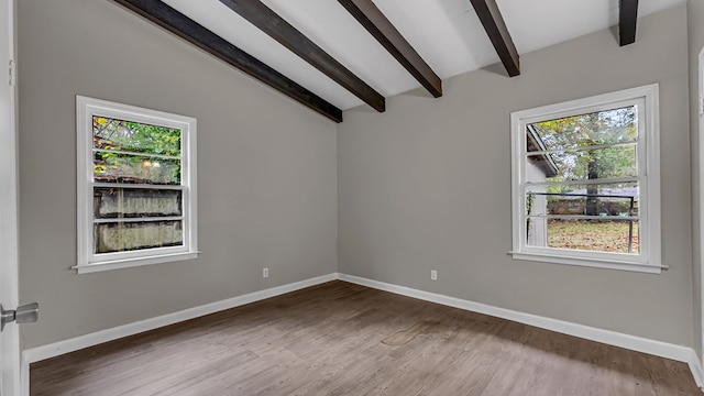 spare room with vaulted ceiling with beams and wood-type flooring