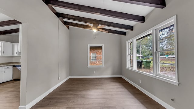 empty room with light wood-type flooring, lofted ceiling with beams, and ceiling fan