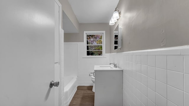 full bathroom with shower / bathing tub combination, vanity, toilet, tile walls, and wood-type flooring