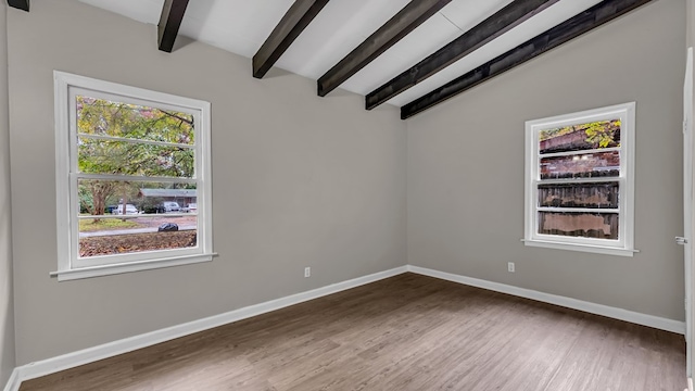 spare room featuring hardwood / wood-style floors and lofted ceiling with beams