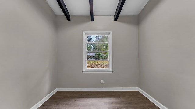 spare room with beamed ceiling and dark hardwood / wood-style floors