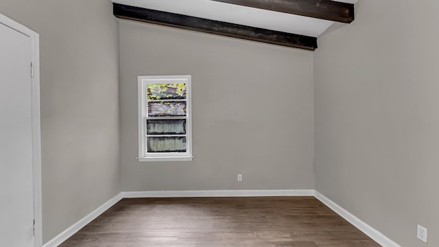 empty room featuring lofted ceiling with beams and dark hardwood / wood-style flooring