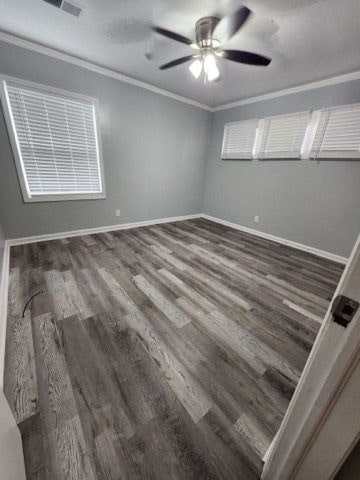 spare room featuring crown molding, ceiling fan, and dark hardwood / wood-style floors