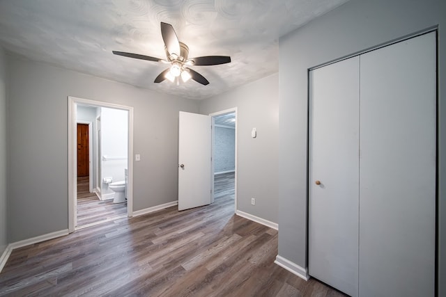 unfurnished bedroom featuring ceiling fan, wood-type flooring, and connected bathroom