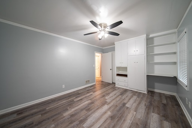 unfurnished bedroom with ceiling fan, dark wood-type flooring, and ornamental molding