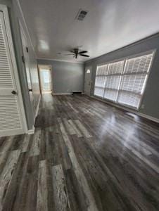 unfurnished living room with dark hardwood / wood-style floors, ceiling fan, and crown molding