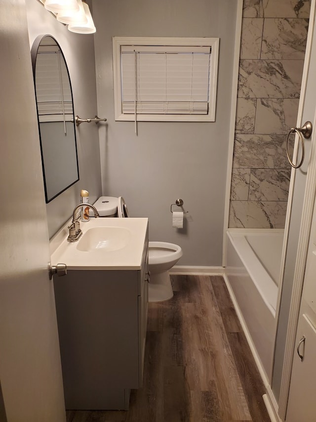 bathroom with wood-type flooring, vanity, and toilet