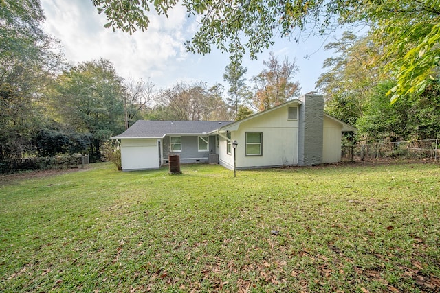 rear view of house featuring a lawn and central AC unit