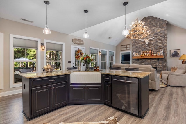 kitchen with pendant lighting, dishwasher, a center island, and vaulted ceiling