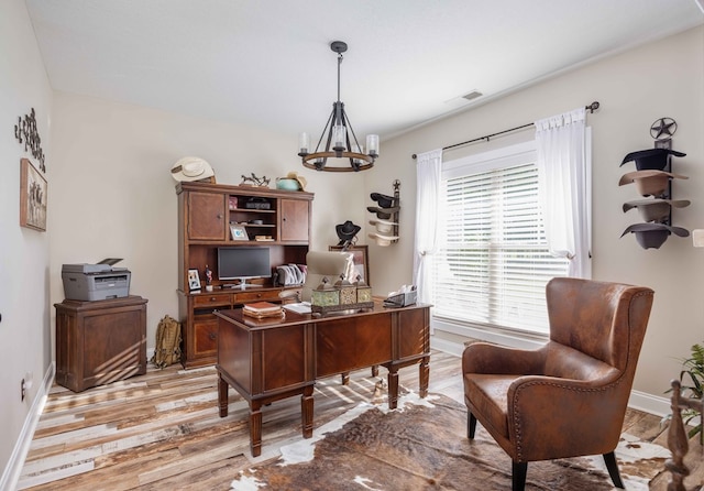 office featuring light wood-type flooring and an inviting chandelier