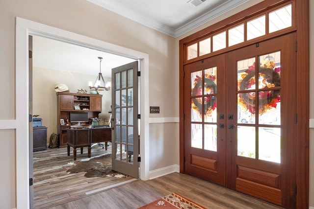 doorway featuring a chandelier, french doors, ornamental molding, and hardwood / wood-style flooring