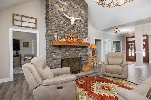 living room featuring high vaulted ceiling, a stone fireplace, crown molding, ornate columns, and wood-type flooring