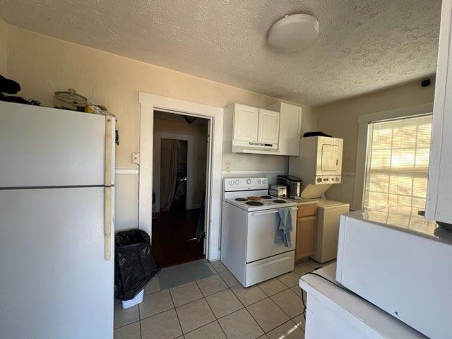 3609 Hamilton Rd, Columbus, GA 31904 - kitchen with white appliances, under cabinet range hood, a textured ceiling, light tile patterned floors, and light countertops