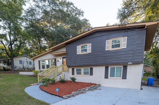 tri-level home featuring a front yard and a patio