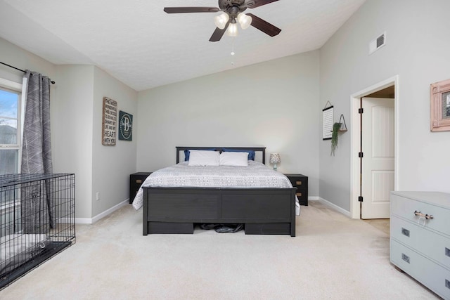 bedroom with light carpet, baseboards, visible vents, and lofted ceiling