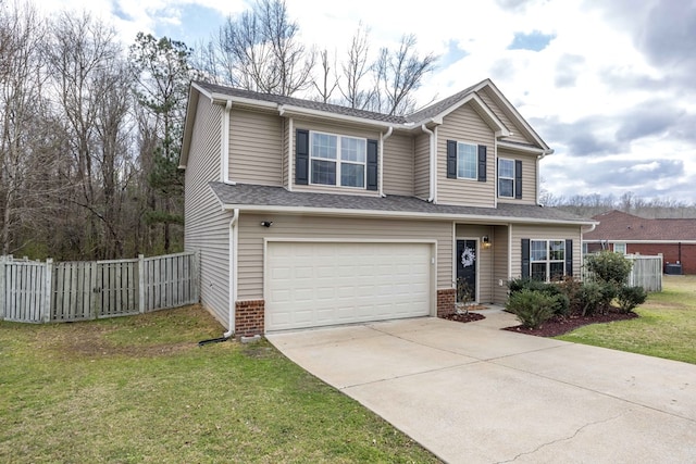 traditional-style house featuring a front yard, fence, driveway, and an attached garage